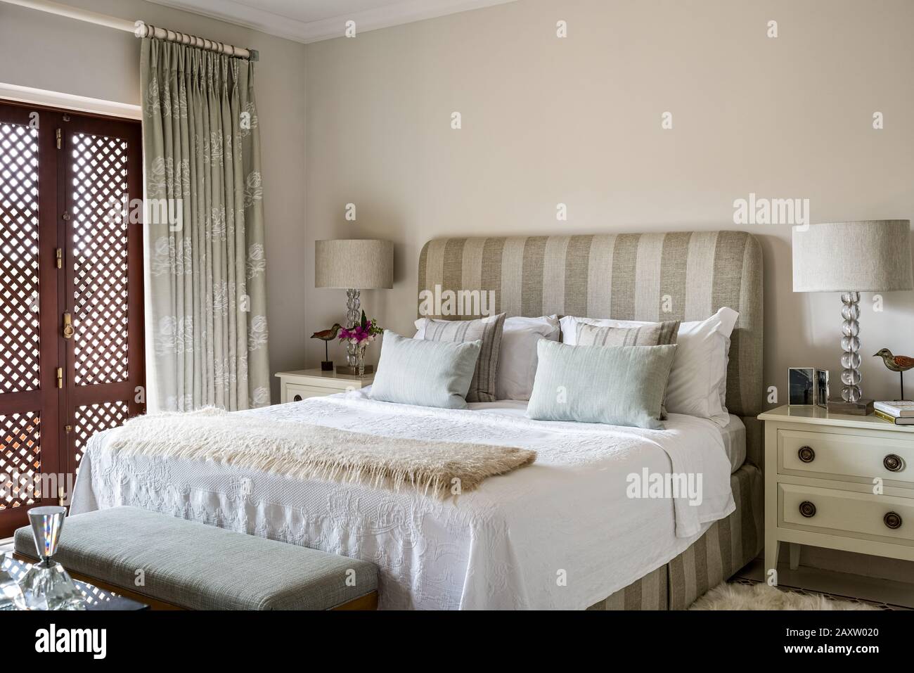 Doppelbett in grauem und weißem Schlafzimmer Stockfoto