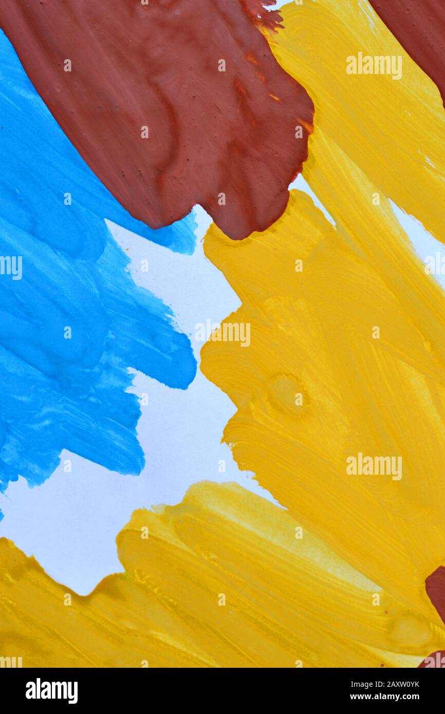 Abstrakte Hintergrundpinselstriche mit gelber, brauner, blauer Tinte auf weißem Papier Nahaufnahme Stockfoto
