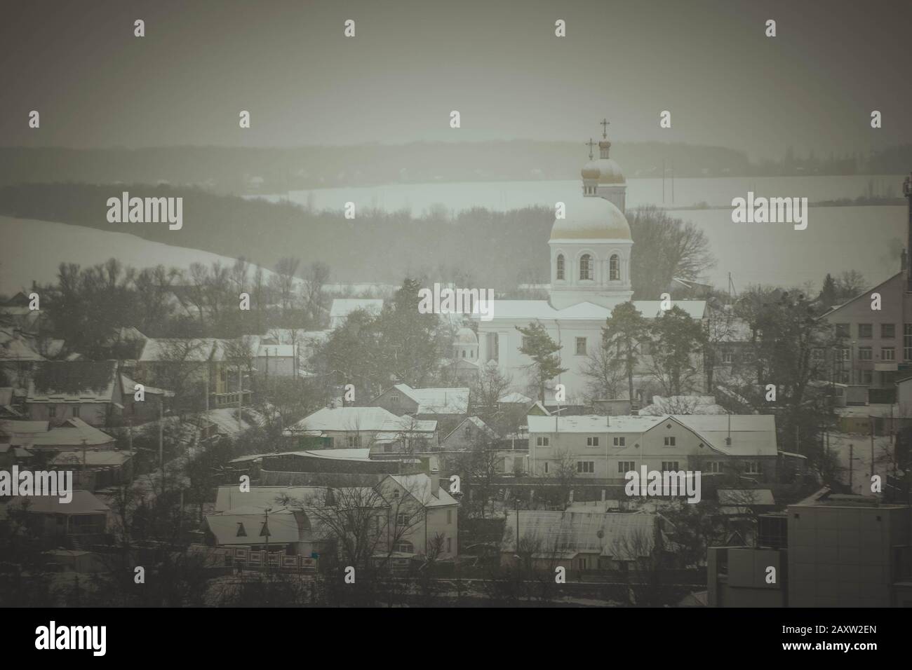 Blick auf das Haus mit der Kirche im Winter-Dunkelfilter Stockfoto