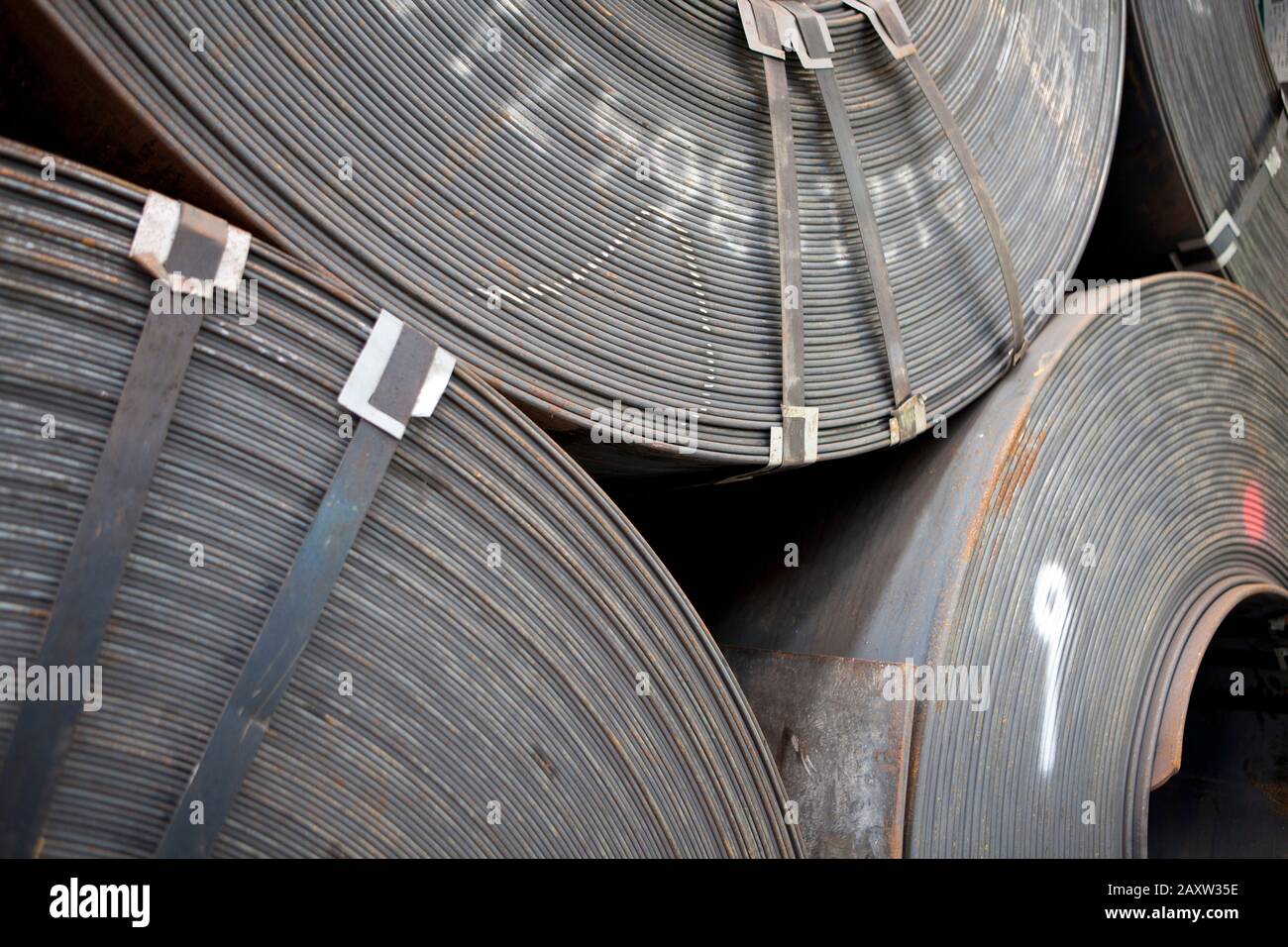Chinesische Stahlrollen gestapelt und bereit für den Transport zum Werk aus dem Lager Stockfoto
