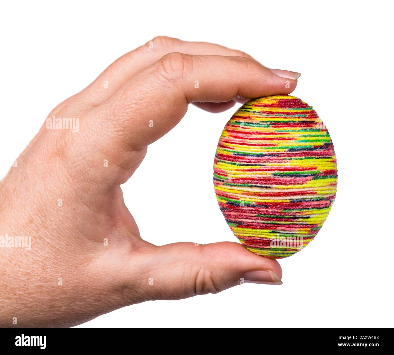 Weibliche Hand, die bunte goldene Easter Eihülle hält. Traditionelle Hühnerhirnschale, dekoriert mit geklebtem, dünnen Garn, das in verschiedenen hellen Farben lackiert ist. Stockfoto