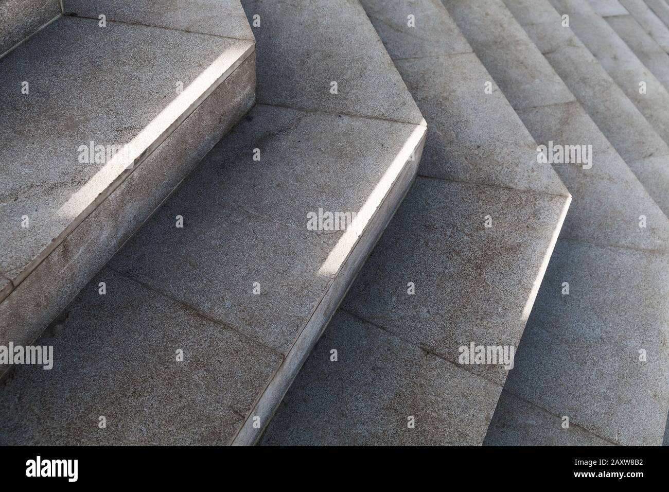 Leere dunkelgraue Steintreppe mit hellem Sonnenlicht darauf. Hintergrundfoto der abstrakten Architektur Stockfoto