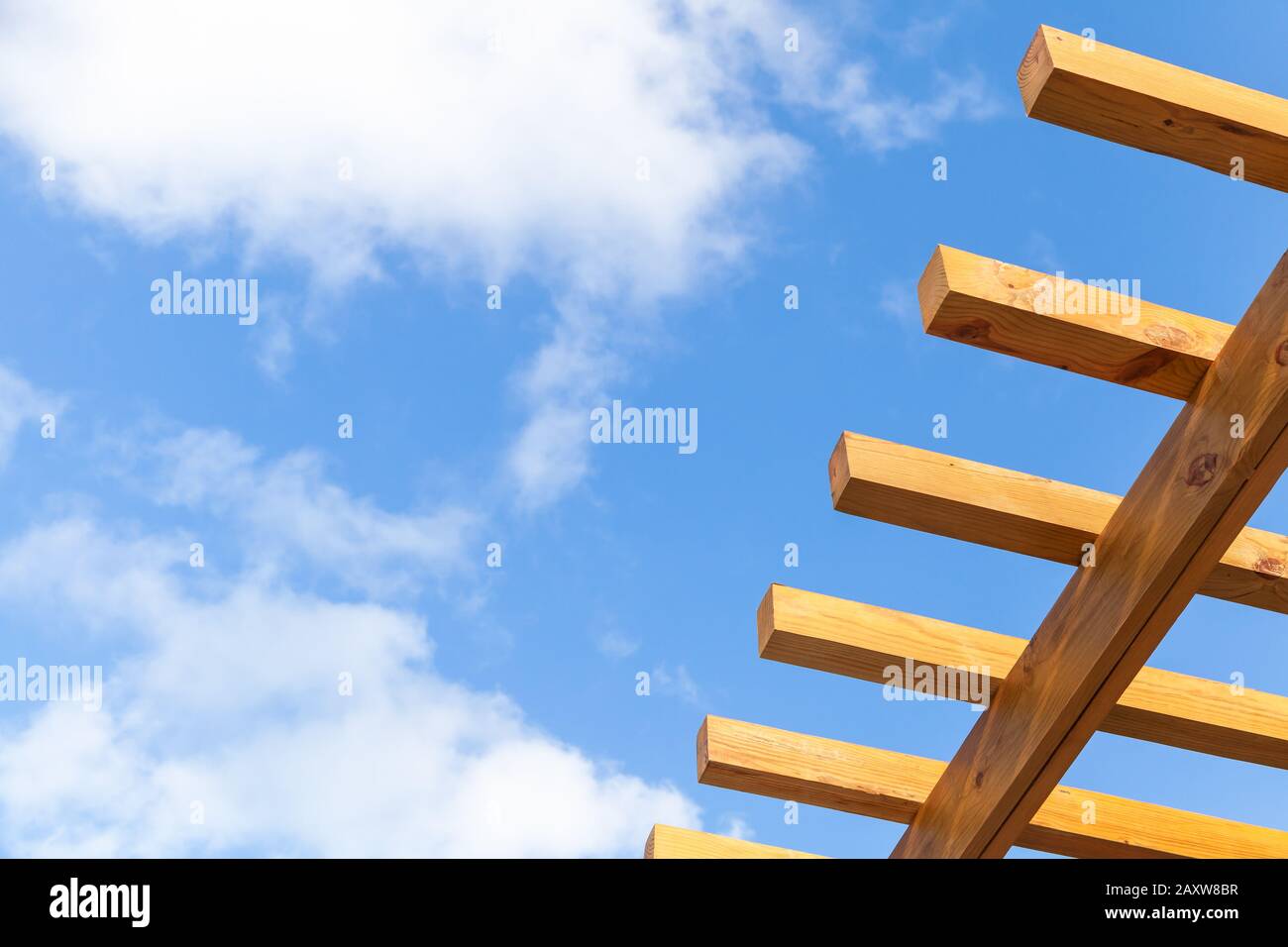 Sonnenschutz-Strukturfragment unter blauem bewölktem Himmel. Holzbohlen Stockfoto