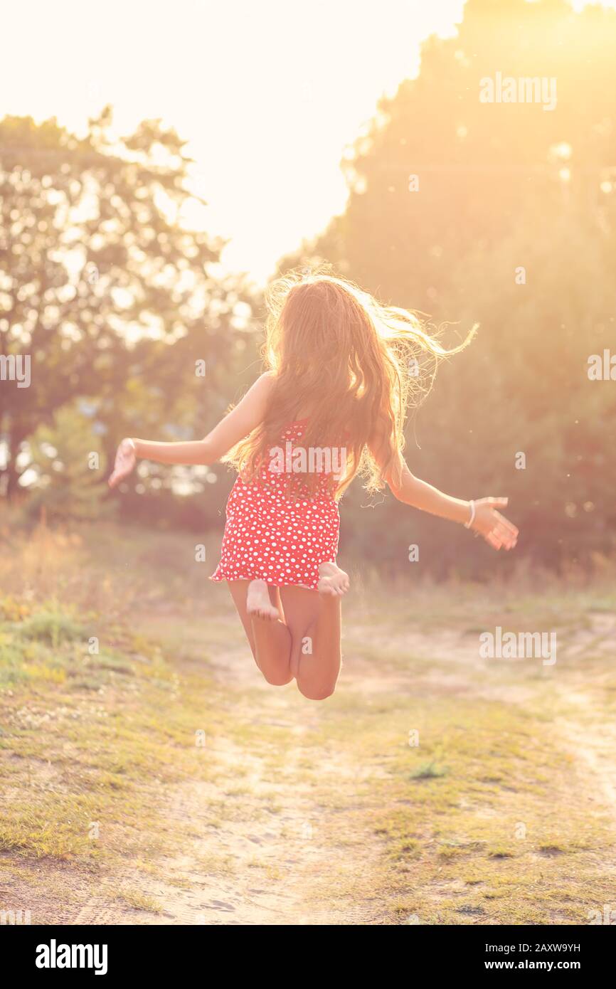 Portrait Des Schönen Teenager-Mädchens springt bei Sonnenuntergang im Sommer nach draußen Stockfoto