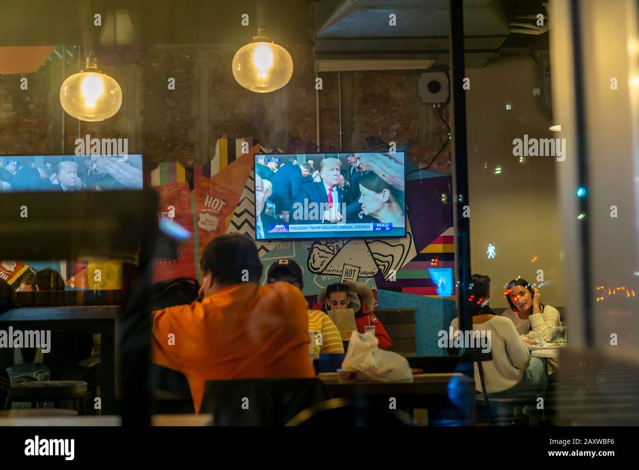 Fernseher in einem Restaurant im New Yorker Stadtteil Chelsea am Dienstag, 4. Februar 2020 zeigen eine Sendung von Donald Trumps Adresse im Bundesstaat der Union. (© Richard B. Levine) Stockfoto