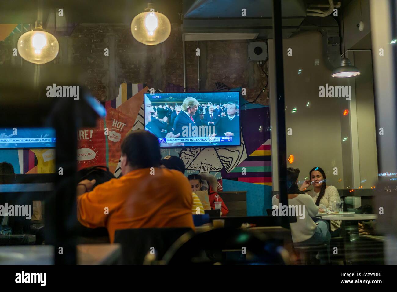 Fernseher in einem Restaurant im New Yorker Stadtteil Chelsea am Dienstag, 4. Februar 2020 zeigen eine Sendung von Donald Trumps Adresse im Bundesstaat der Union. (© Richard B. Levine) Stockfoto