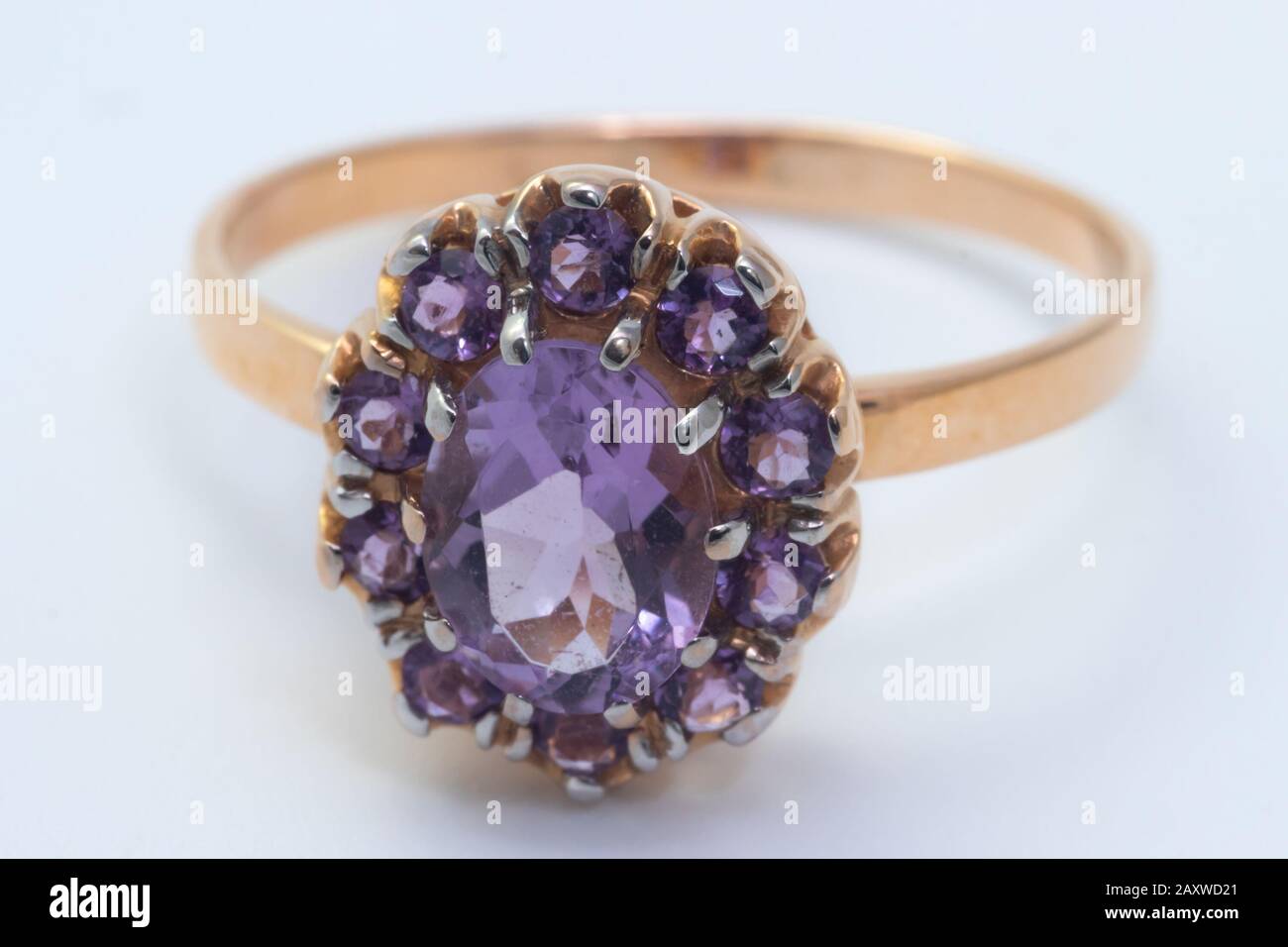 Schöner goldener Ring mit violettem Edelstein isoliert auf weißem Grund Stockfoto