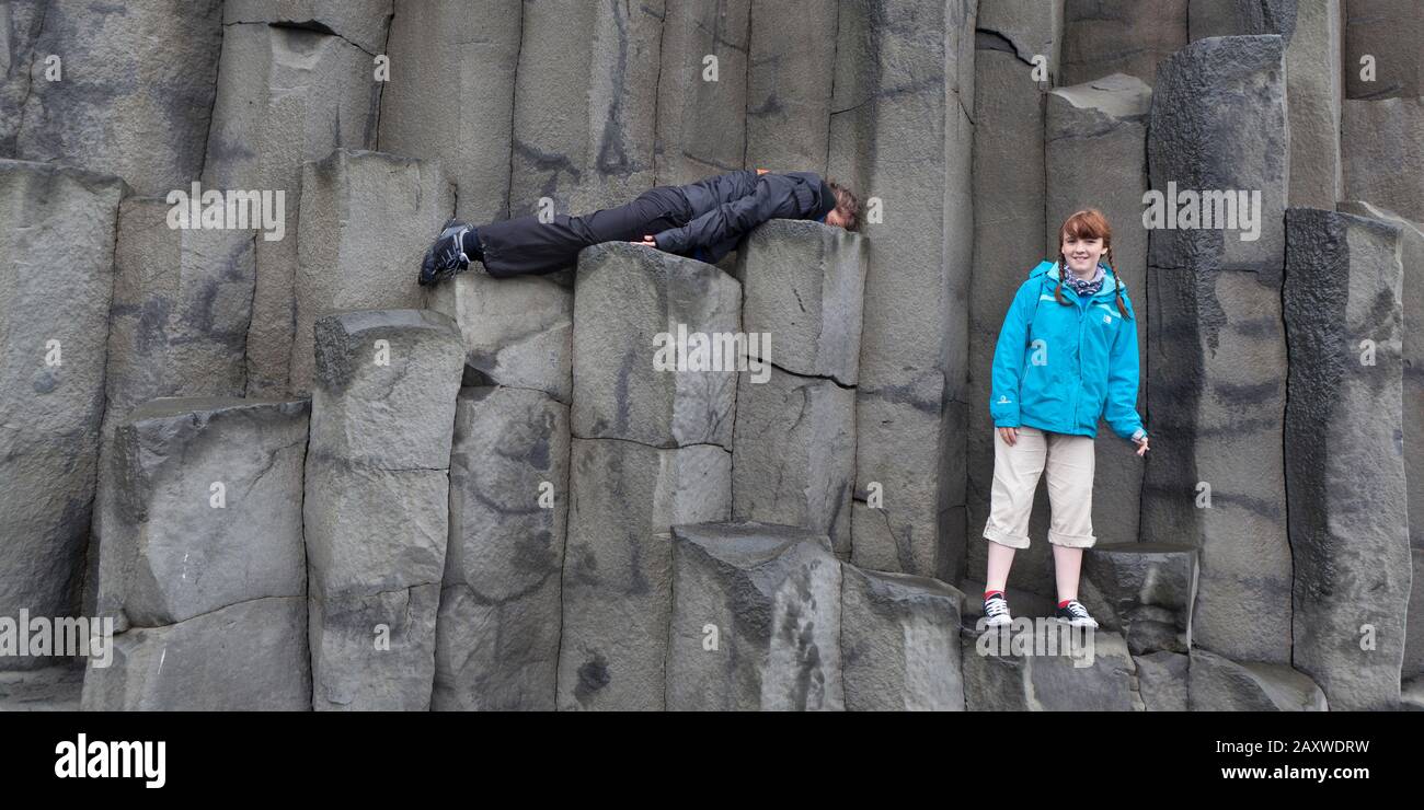 Jugendliche auf Basaltsäulen in Reynisfjara, Südküste, Island Stockfoto