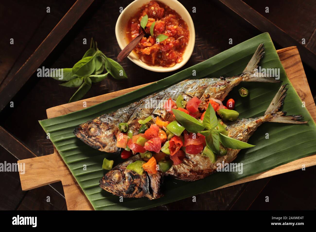 Ikan Tude Bakar Sambal Dabu. Minahasan-Gericht mit gegrilltem Makrelen mit würzigen Salsa mit Tomaten und Chilipapierern Stockfoto