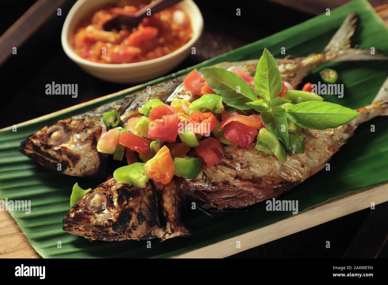 Ikan Tude Bakar Sambal Dabu. Minahasan-Gericht mit gegrilltem Makrelen mit würzigen Salsa mit Tomaten und Chilipapierern Stockfoto