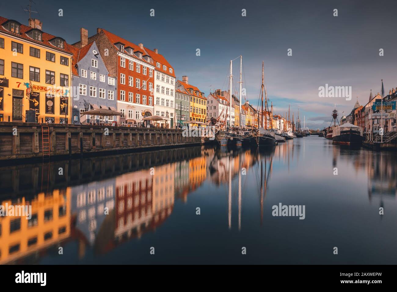 Lange Sicht auf den berühmten Nyhavn von Dänemark im Zentrum Kopenhagens mit den farbenfrohen, bemalten Gebäuden mit geparkten Booten. Stockfoto