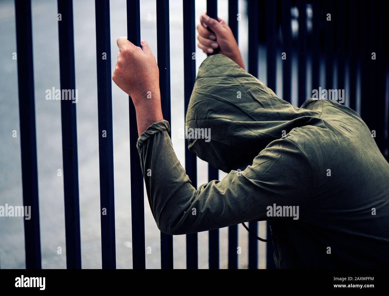 Hände Mann des Häftlings auf einem Stahlgitter nah beieinander Stockfoto