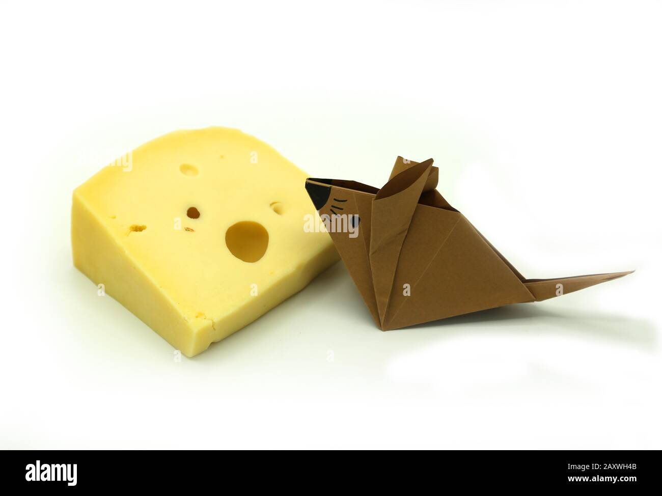 Braune Origami-Maus in der Nähe einer großen Scheibe Käse isoliert auf wihite Hintergrund. Kopierbereich. Stockfoto