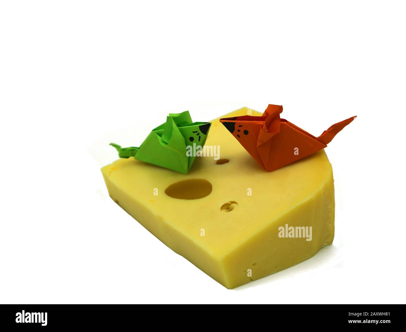 Orangefarbene und grüne Origami-Maus in der Nähe einer großen Scheibe Käse isoliert auf wihite Hintergrund. Kopierbereich. Stockfoto