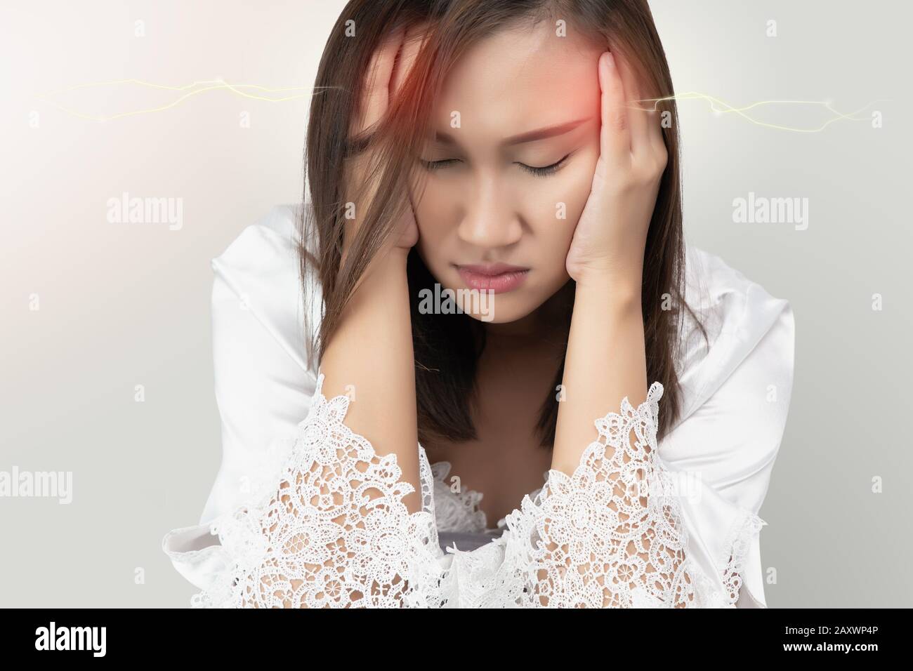 Asiatische Frauen in Spitzen- und weißen Satingewändern haben Kopfschmerzen, isoliert auf grauem Hintergrund. Migräne leiden. Stockfoto