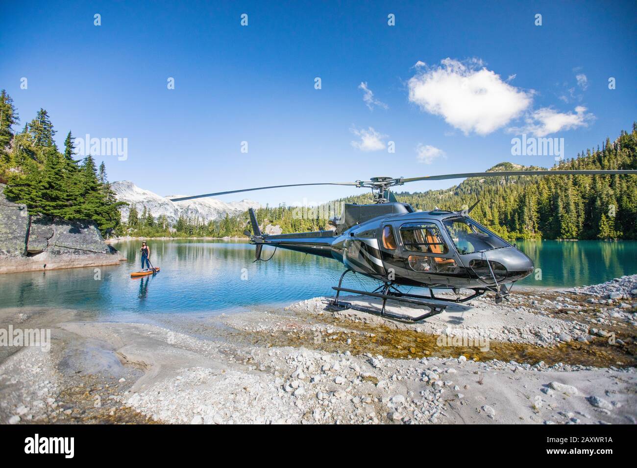 Weibliche Paddle Boards auf dem See neben ihrem Hubschrauber Stockfoto