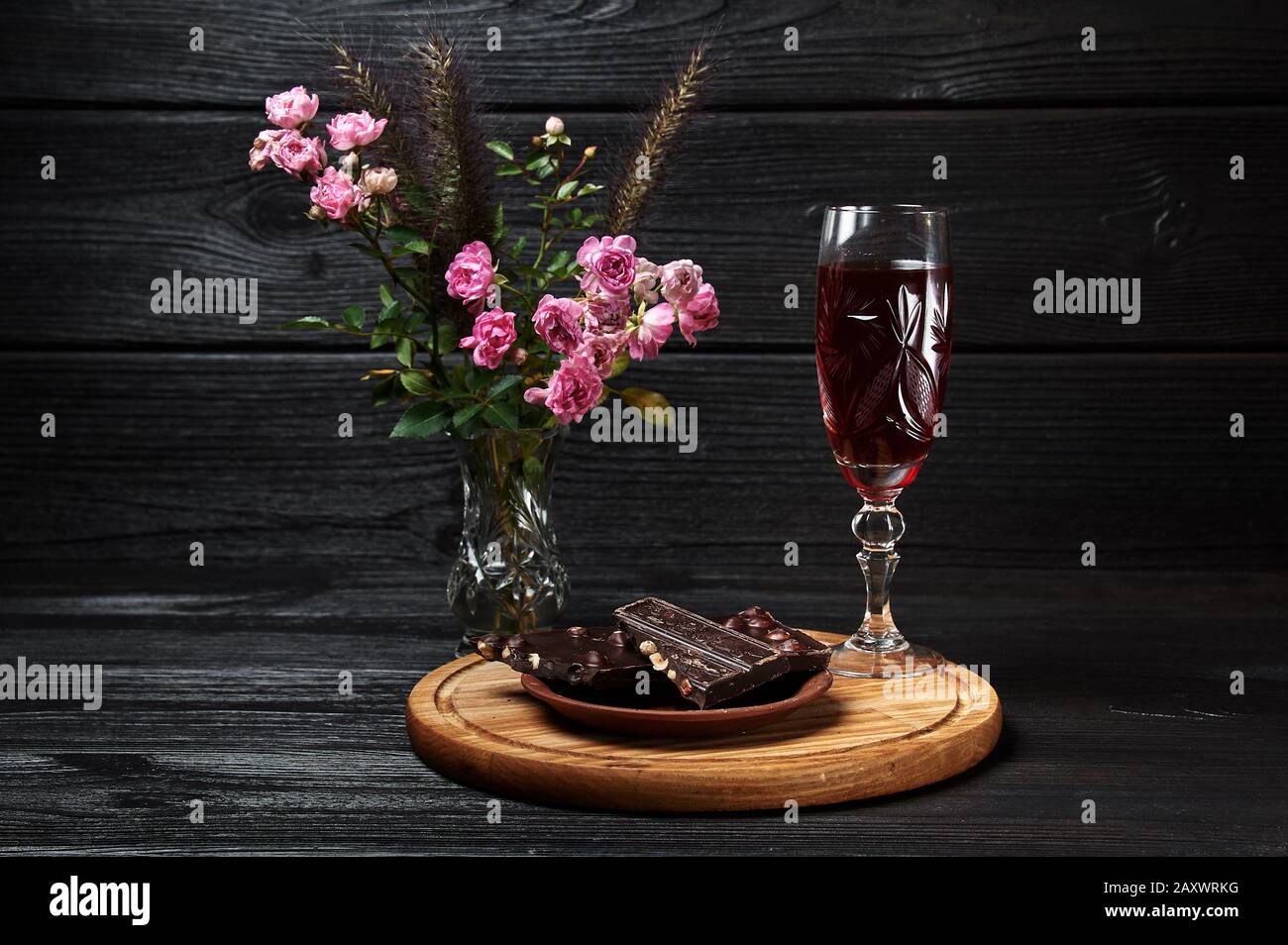 Schwarze Schokolade Stillleben auf schwarzem Grund mit einem Glas Wein Stockfoto