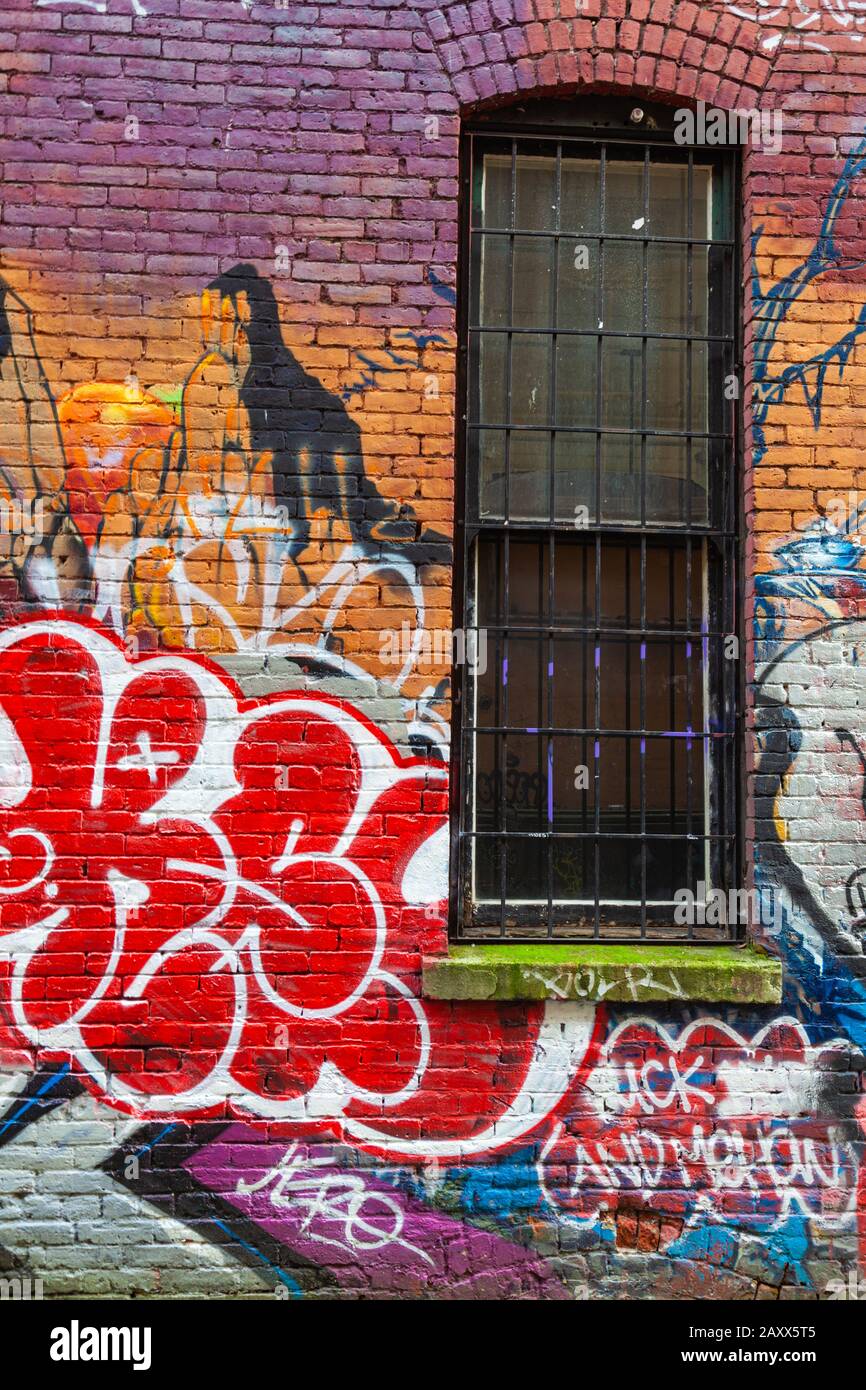 Graffiti, die auf die Ziegelwände einer Hintergasse im Gastown Distrikt von Vancouver Canada gemalt wurden Stockfoto