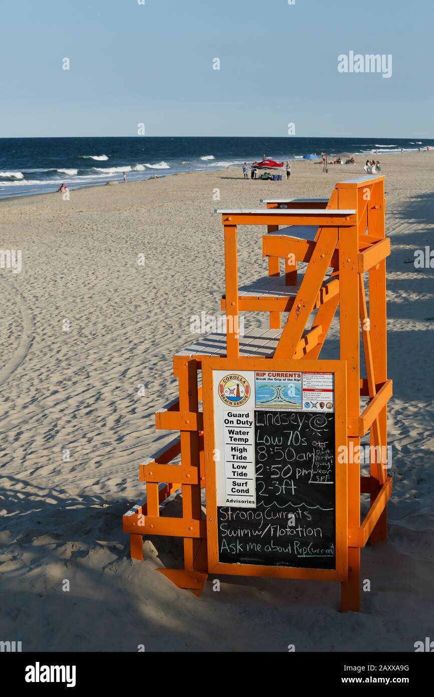 Outer Banks, NC, 4. Juni 2019, EIN heller, sonniger Frühabend an einem fast leeren Strand mit einem dominanten orangefarbenen Rettungsstand. Stockfoto