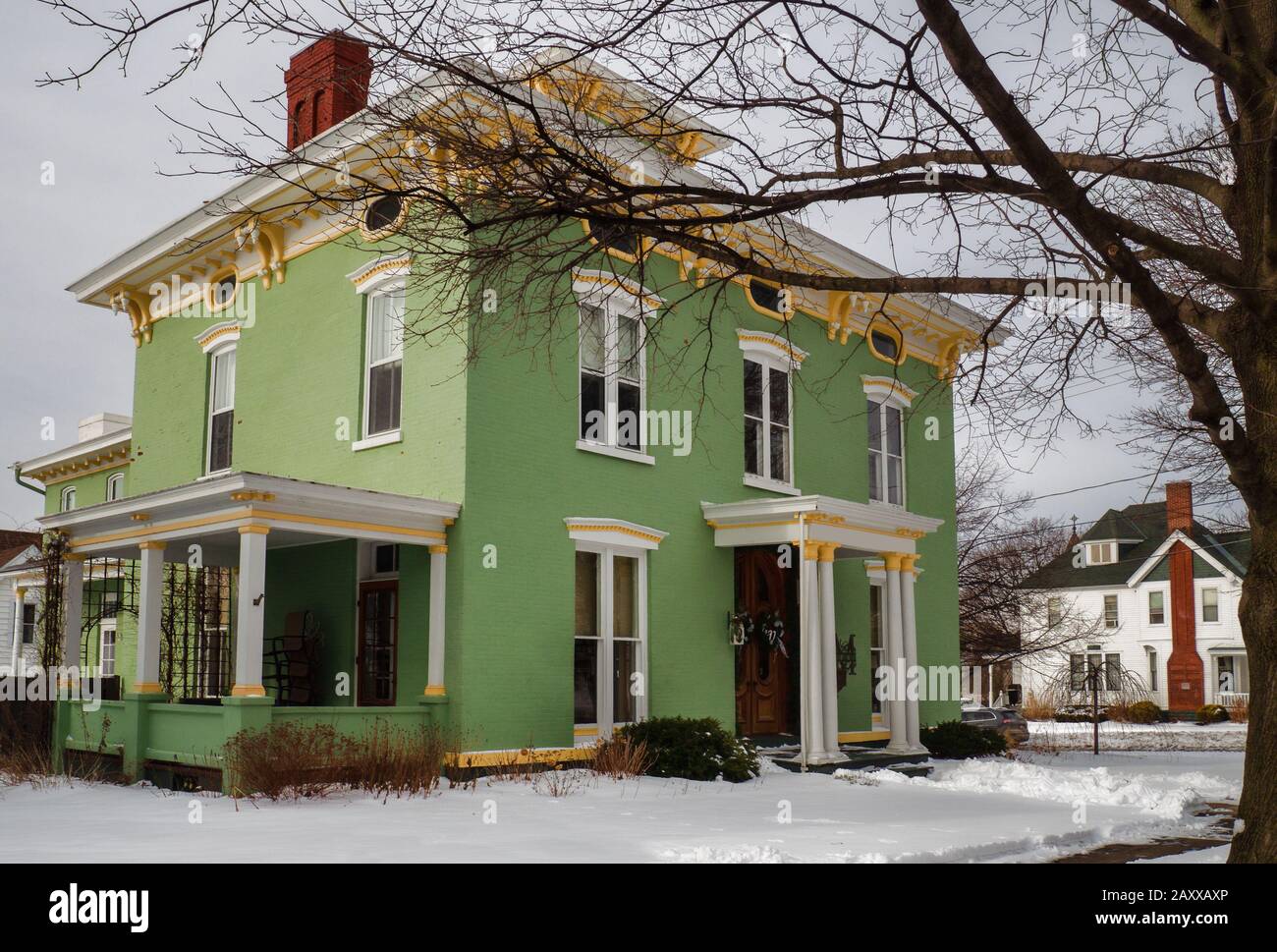 Hübsches grünes Haus mit gelber Verkleidung im italienischen Architekturstil an einem Wintertag Stockfoto