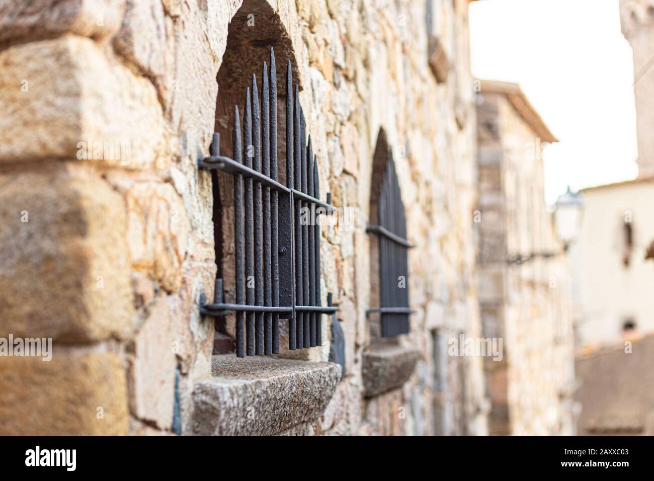 Eisengitter am Fenster eines alten Steinhauses In Spanien Stockfoto