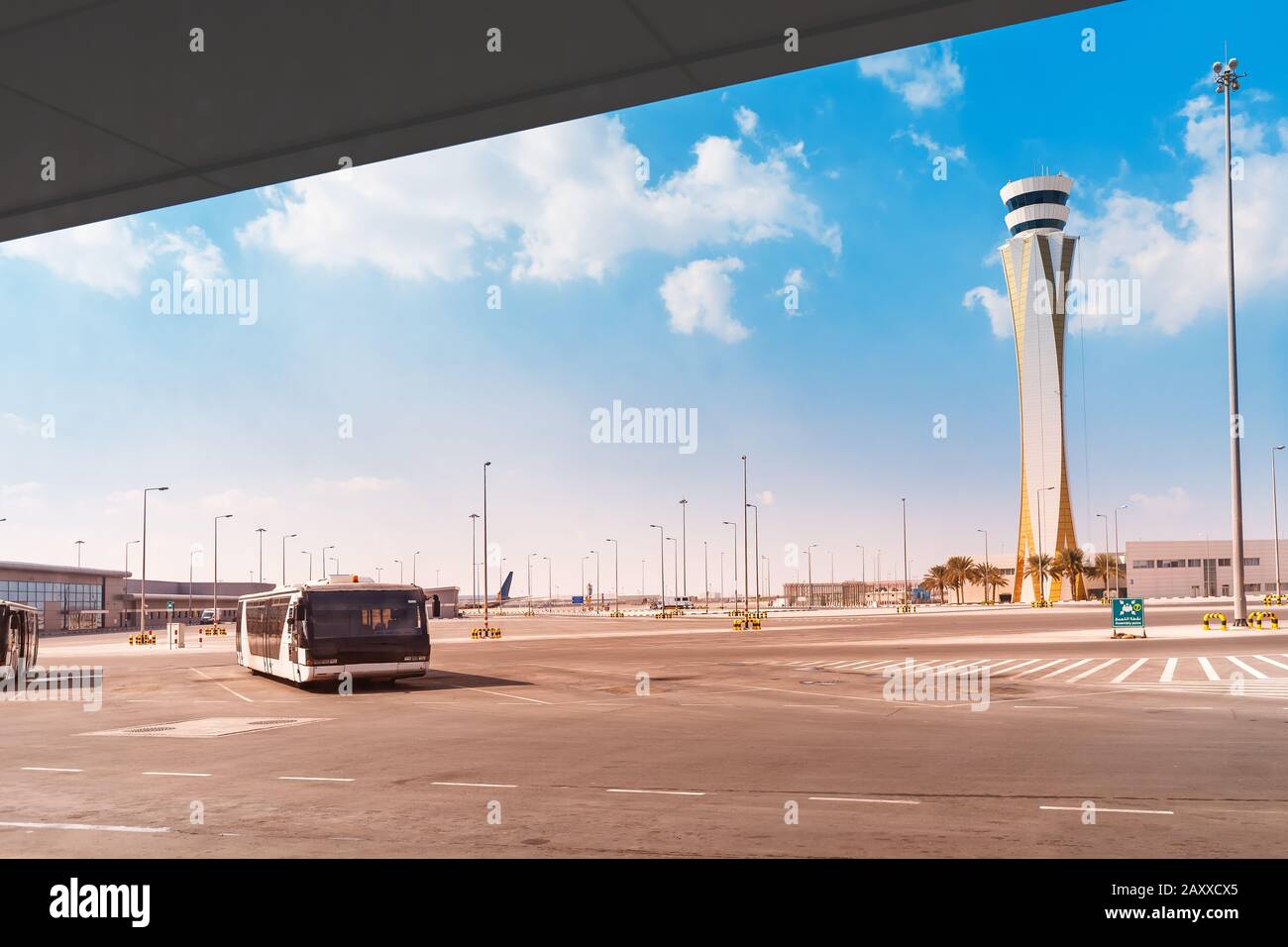 Flughafeninfrastruktur - ein Personenbus und ein Kontrollturm Stockfoto