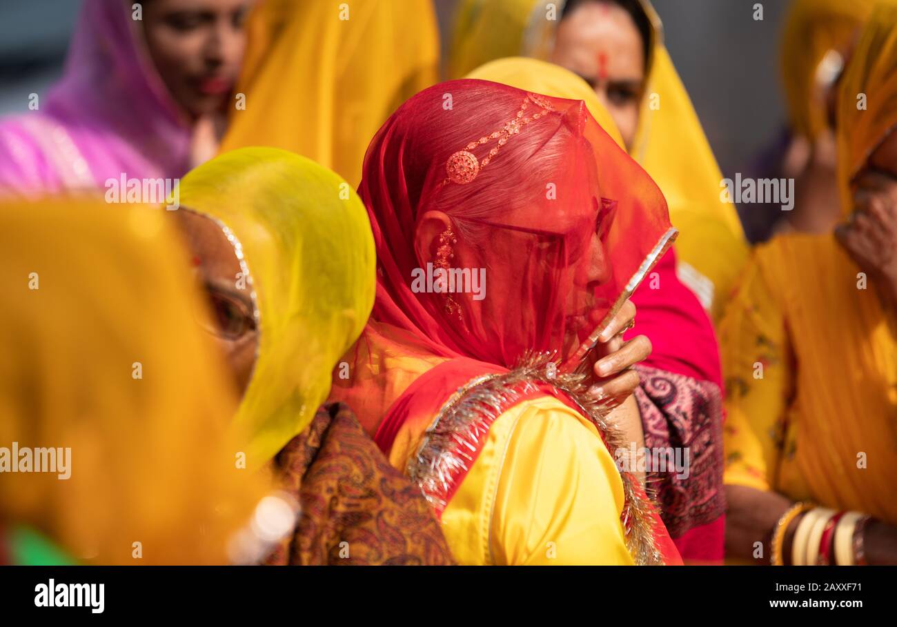 Indische Rajasthani-Frauen in Farbenfrohem Kleid rot Und gelb unter Duppata Stockfoto