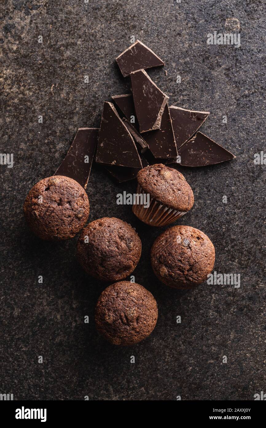 Schmackhafte Schokoladenmuffins. Süße Cupcakes und Schokolade auf dem alten Küchentisch. Draufsicht. Stockfoto