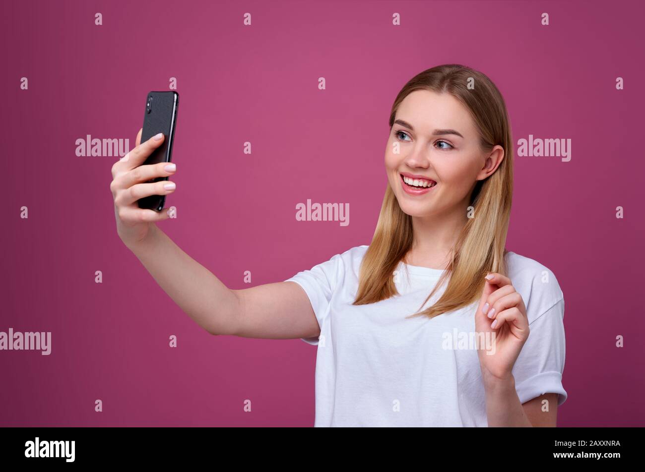 Porträt einer jungen attraktiven Frau, die selfie Foto auf Smartphone isoliert macht. Blonde Frau Stockfoto