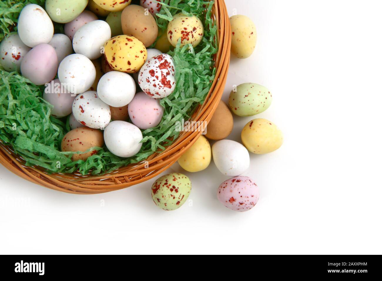 Schokolade mini Ostern Eier im Stroh oder whicker Korb vor einem weißen Hintergrund Stockfoto