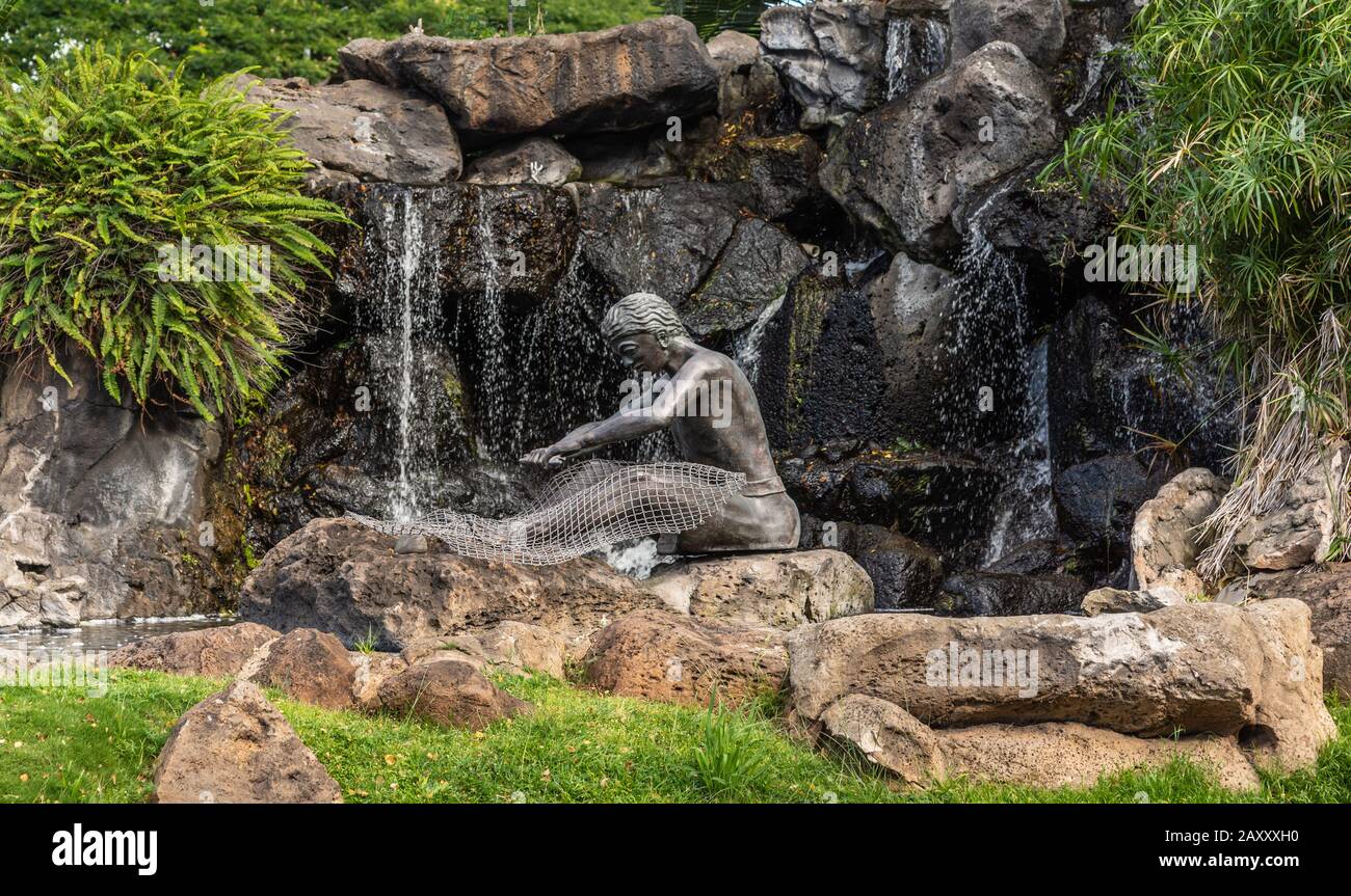 Honolulu Oahu, Hawaii, USA. - 10. Januar 2012: Bronzener hawaiischer Net Mender Fountain und Statue auf dem Dreieckspark, wo Kapiolani Blvd und S. King Stre Stockfoto