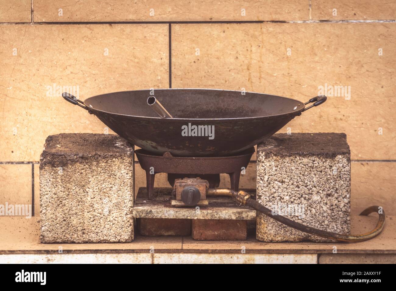 Alte schwarze Metallpfanne wok auf einem Gaskocher auf einem  Straßenlebensmittelstand in China Stockfotografie - Alamy