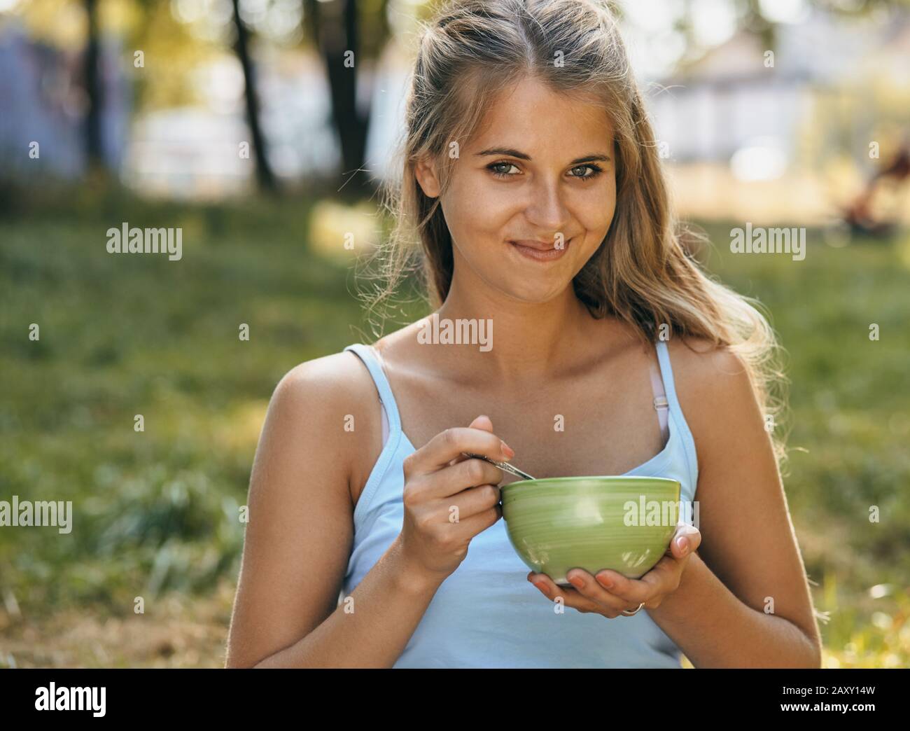 Porträt einer fröhlichen lächelnden jungen Frau, die Nudeln isst Stockfoto