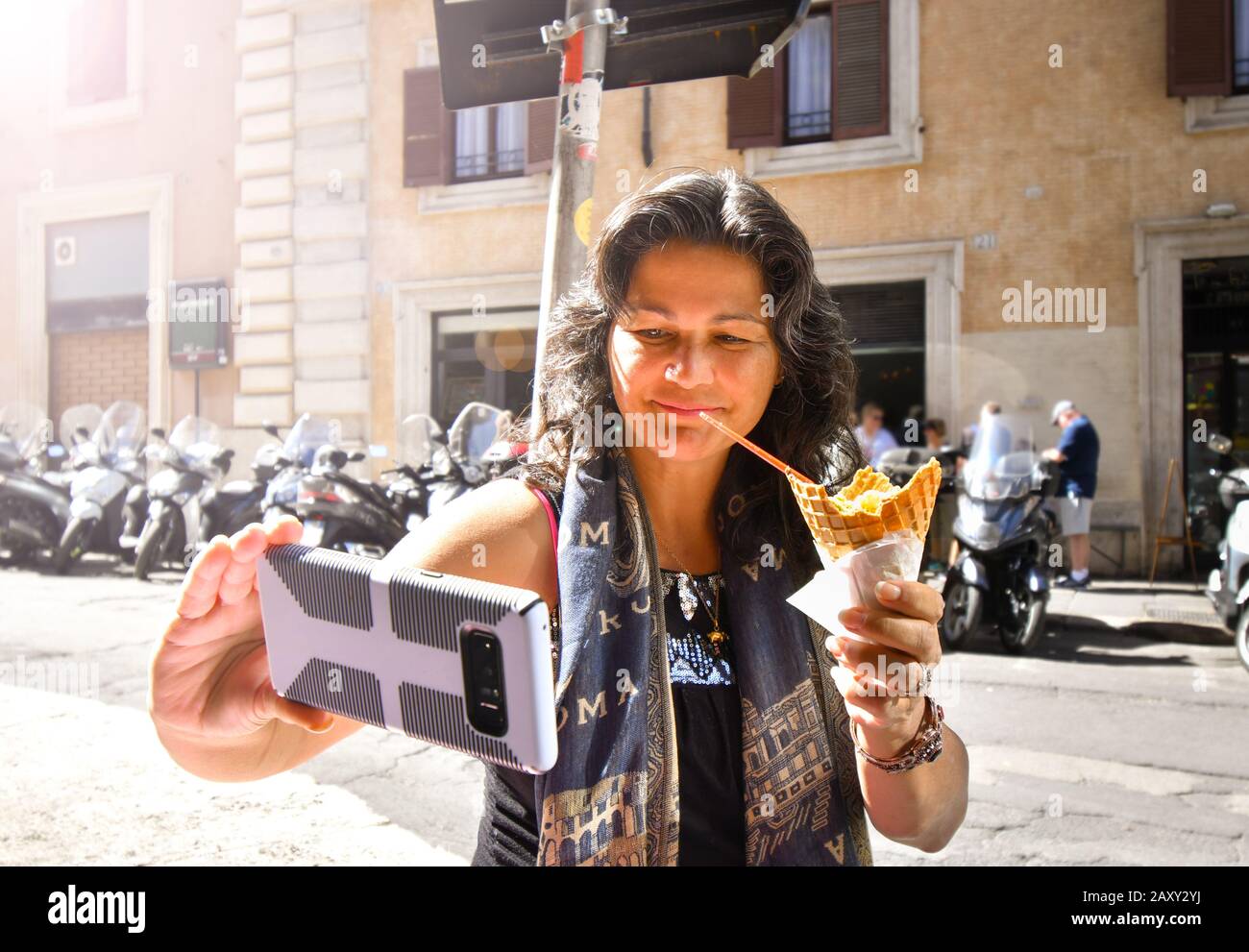 Eine kaukasische hispanische Frau nimmt beim Essen von Eisgelato in Rom, Italien, eine selfie. Stockfoto