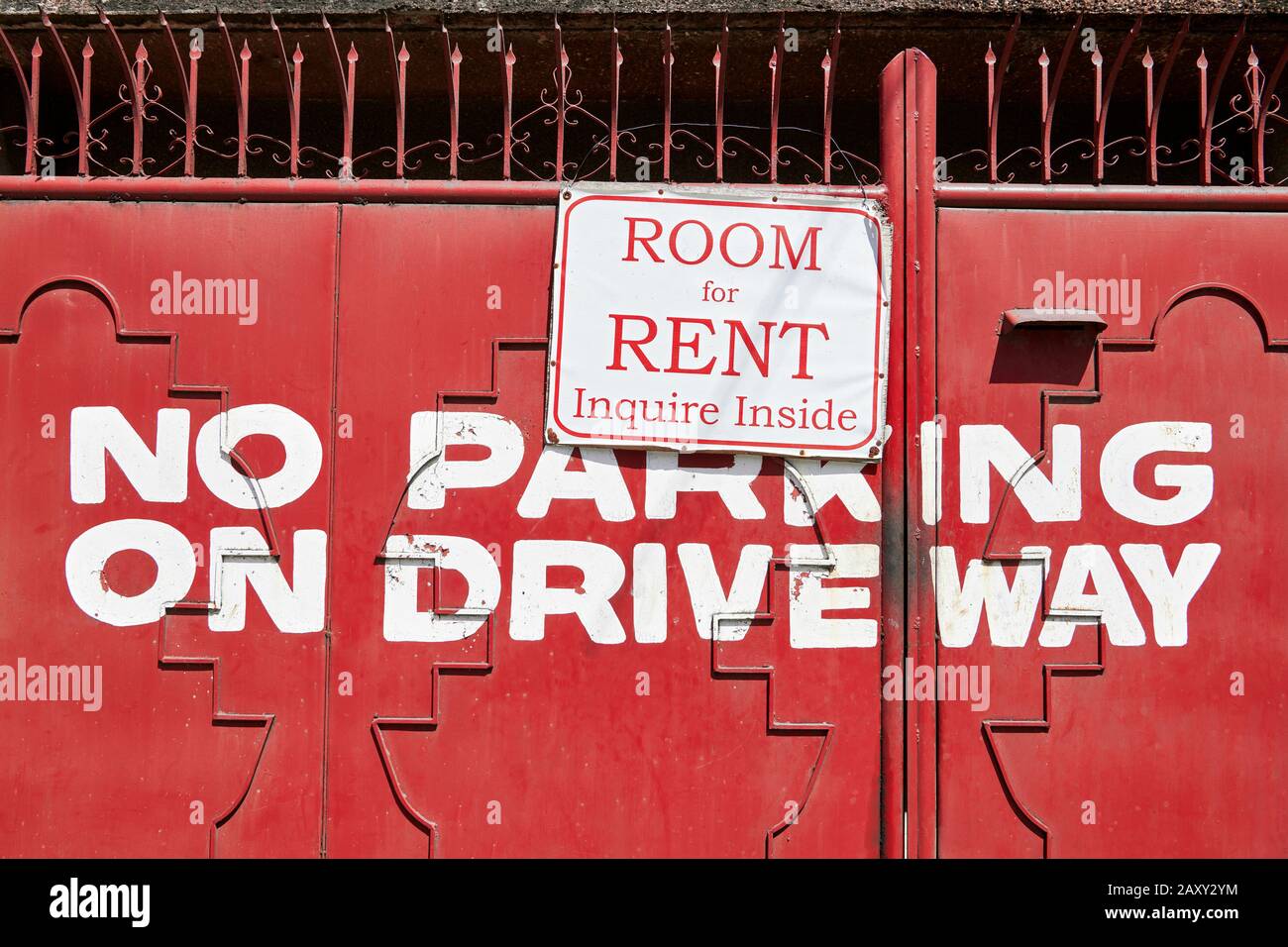 Schild mit anbietendem Mietraum, das vor einem rot lackierten alten Metalltor hängt. Kein Parkplatz auf dem Weg zum Auto, auf dem Tor, auf den Philippinen, Asien Stockfoto