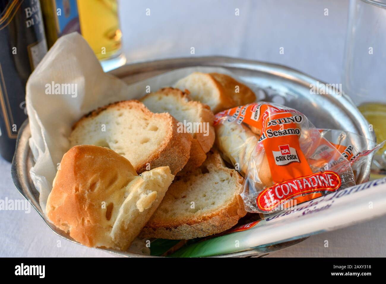 Ein typischer Korb mit Brot und Brötchen, der in einem italienischen Restaurant zum Tisch gebracht wurde. Stockfoto