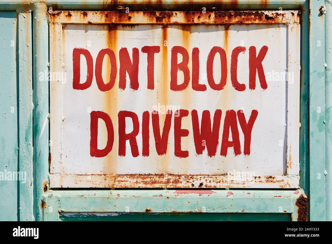 Nahaufnahme eines rostigen, bemalten Schildes "Don't Block the Driveway", das in roten Buchstaben auf einem Metalltor geschrieben ist, zu sehen in Iloilo, Philippinen, Asien Stockfoto