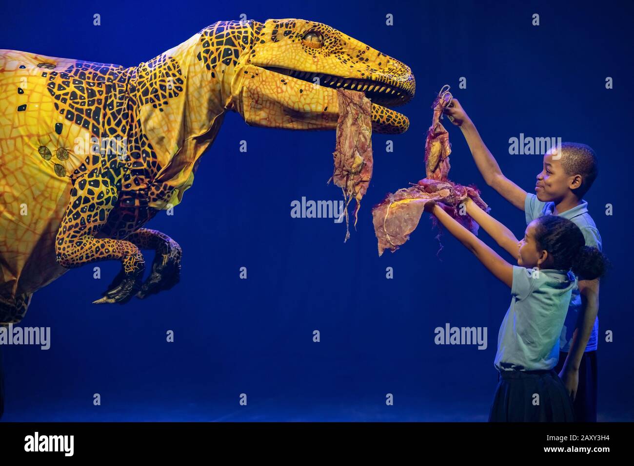 Kinder der Stockwell Primary School treffen lebensähnliche Dinosaurier-Marionetten, die derzeit im Erth's Dinosaur Zoo im Southbank Center, London, Großbritannien, erscheinen. Stockfoto