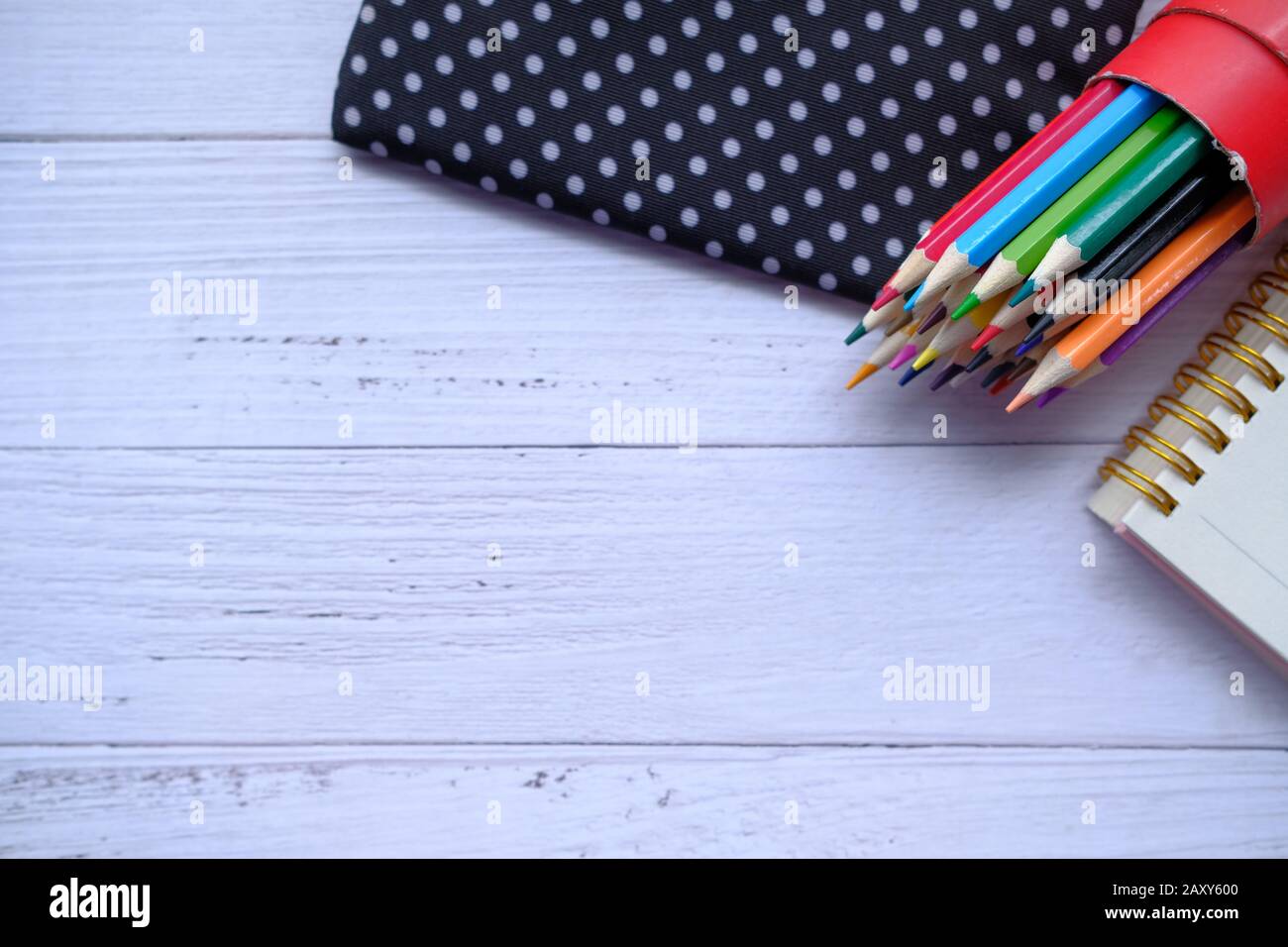 Draufsicht über Farbstifte und Notizblock auf dem Tisch Stockfoto