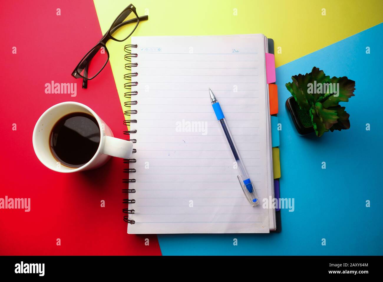 Draufsicht auf Notizblock und Kaffee auf Farbhintergrund Stockfoto