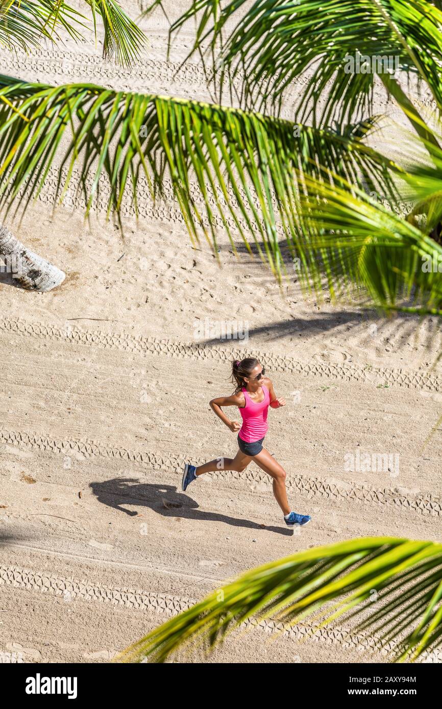 Gesunde Aktiv-Sport-Frau trainiert Kardio am tropischen Strand zwischen Palmen. Ansicht von oben. Gesundheits- und Fitnesskonzept. Stockfoto