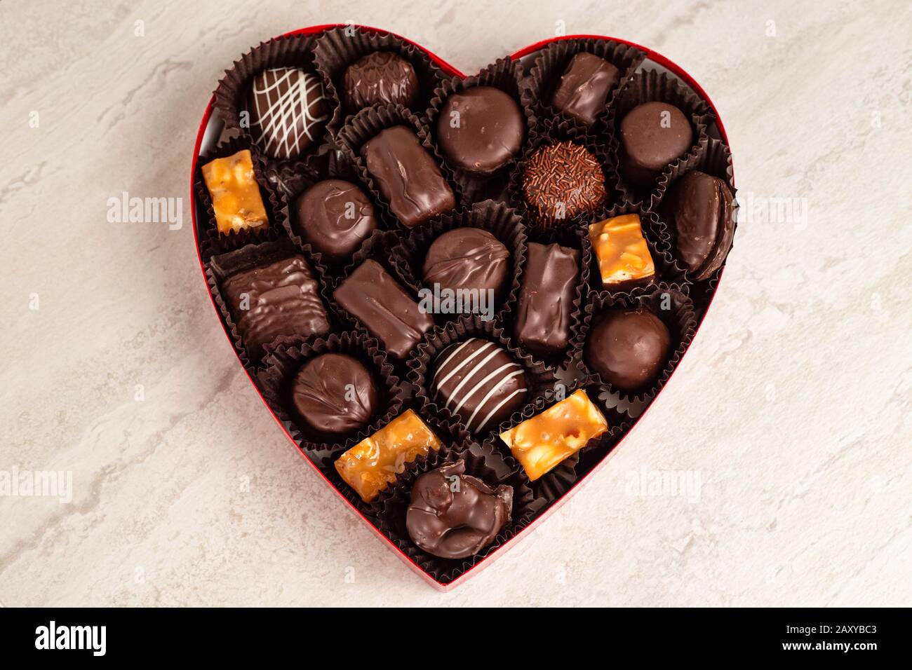 Köstliche Pralinen in einer herzförmigen Schachtel Stockfoto