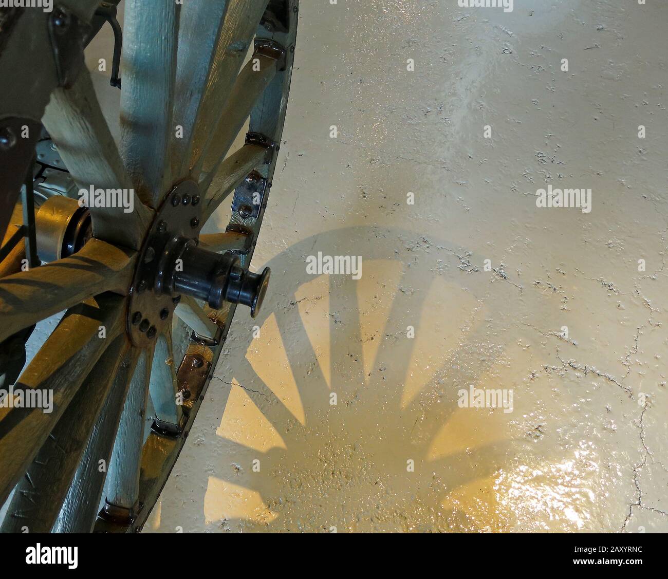 Ein Rad einer alten Kanone mit Schatten auf dem Betonboden Stockfoto