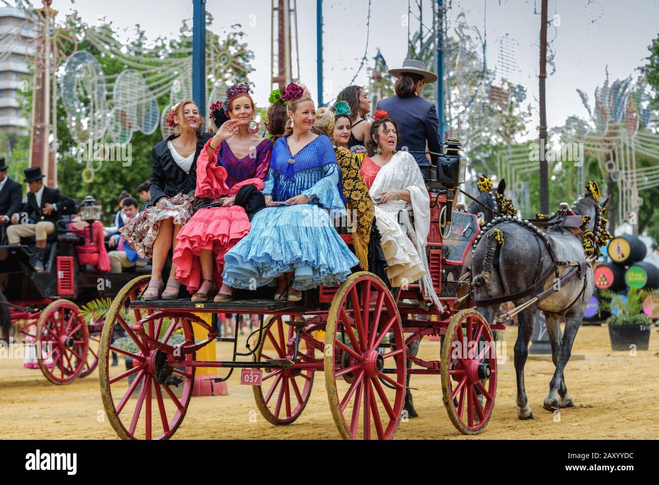 Frauen, die traditionelle spanische Kleider tragen, die auf der Kutsche fahren, Jerez Horse Fair (Feria de Caballo), Jerez de la Frontera, Andalusien, Spanien Stockfoto