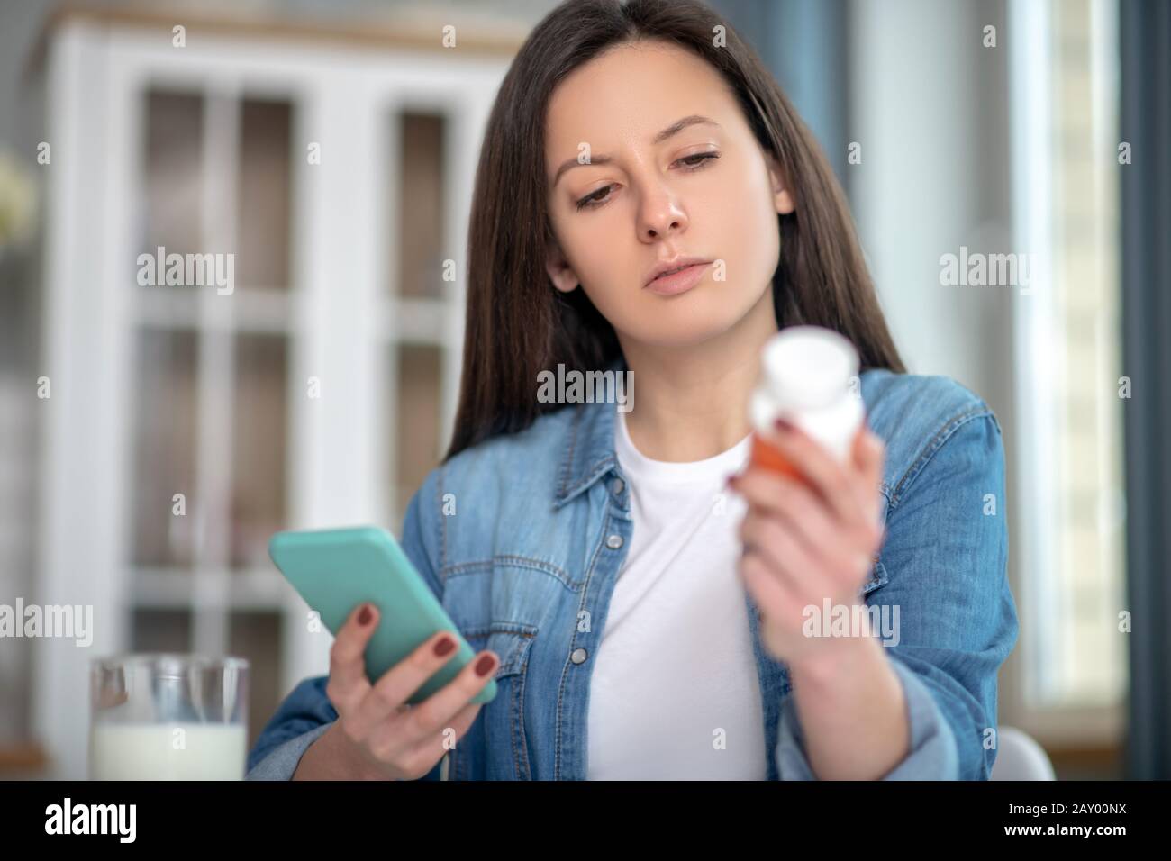 Frau, die mit ihrem Smartphone nach der Anweisung für Drogen sucht Stockfoto