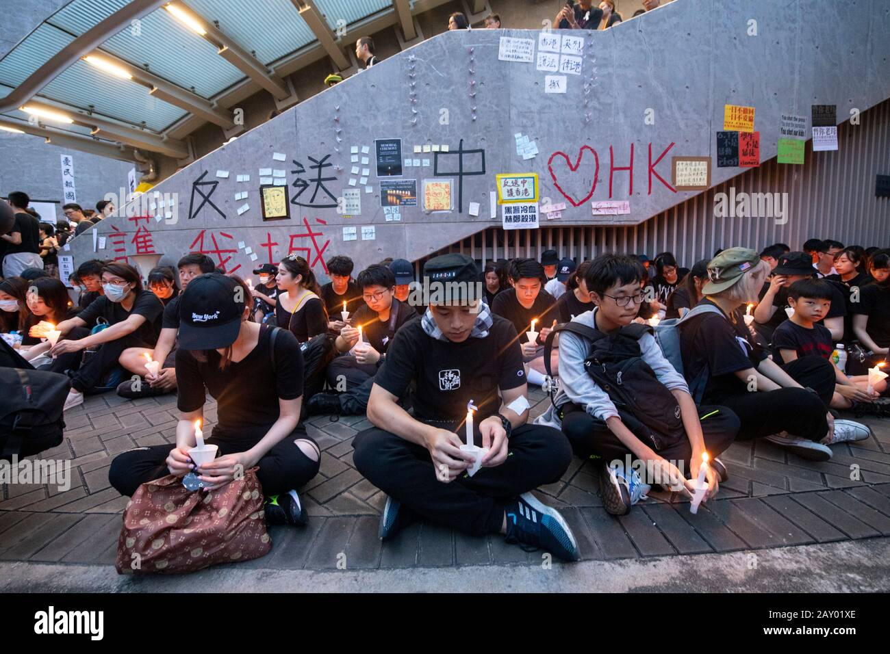 Hongkong, China: 16. Juni 2019. Demonstranten halten während eines Sit-in von Lennon Wall Kerzen in Erinnerung an "Regenmantel man", einen Protestler, der bei dem Versuch starb, sich zu entfellen Stockfoto