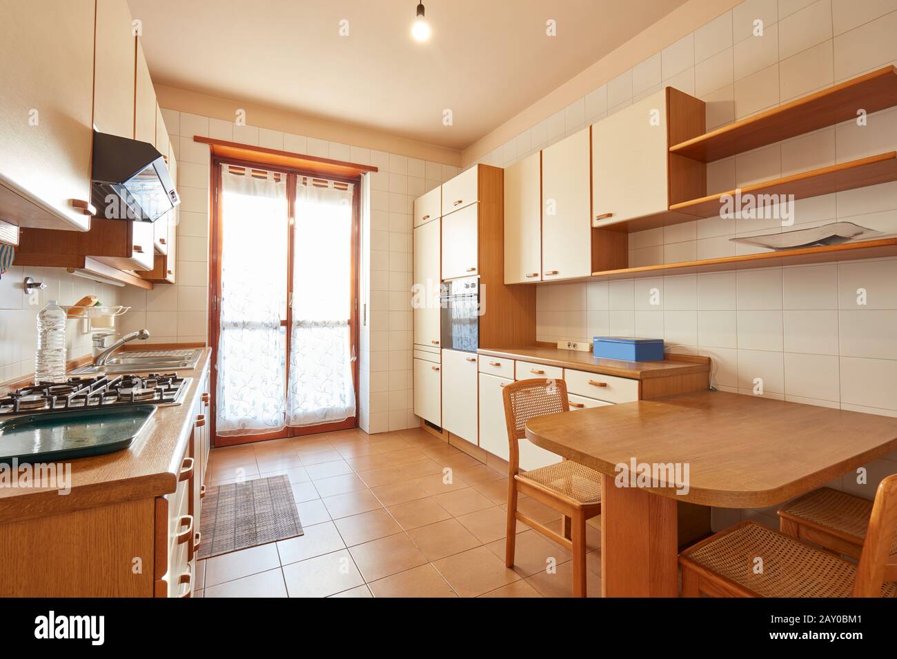 Kücheneinrichtung mit Holztisch an einem sonnigen Tag in normaler Wohnung Stockfoto