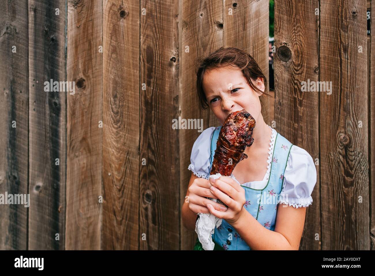 Mädchen, die an einem Zaun stehen und ein gegrilltes putenbein essen, USA Stockfoto