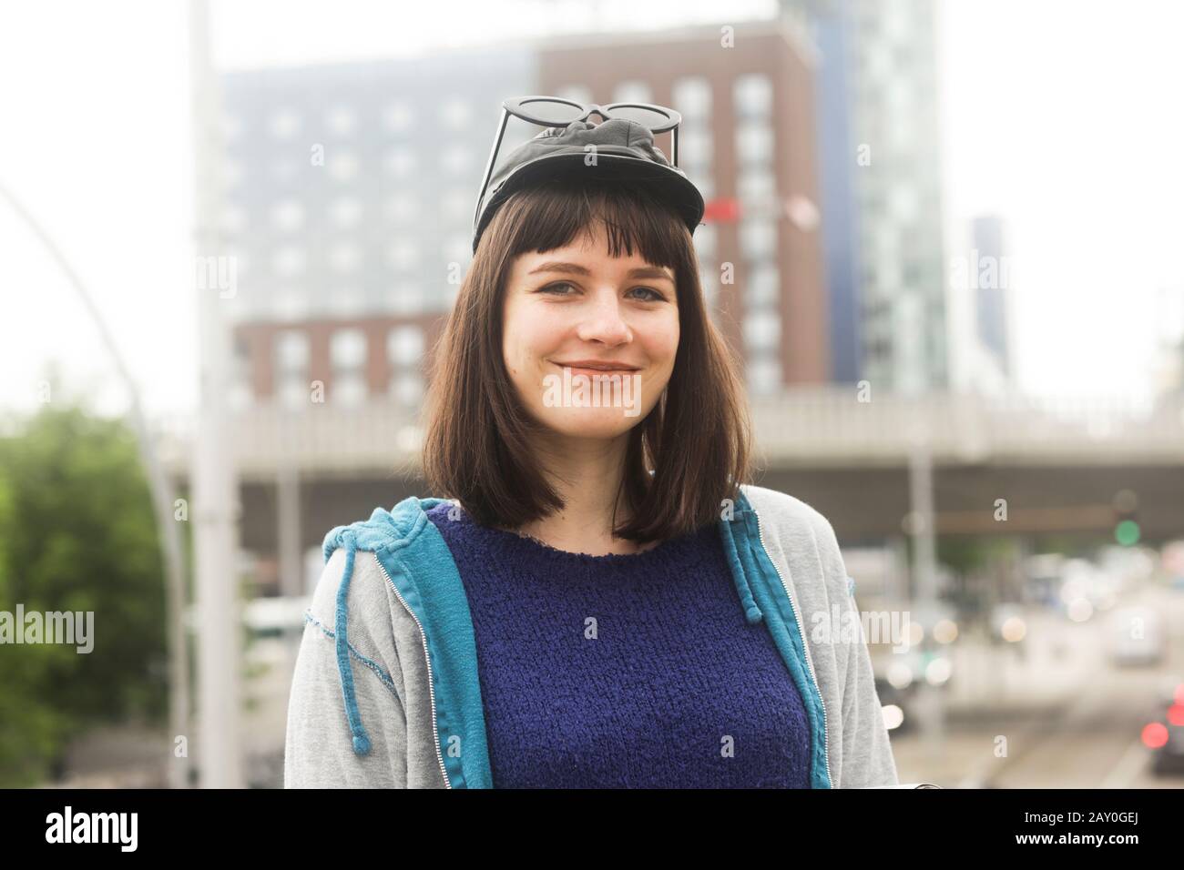 Porträt einer lächelnden Frau, die im Freien in der Stadt steht Stockfoto