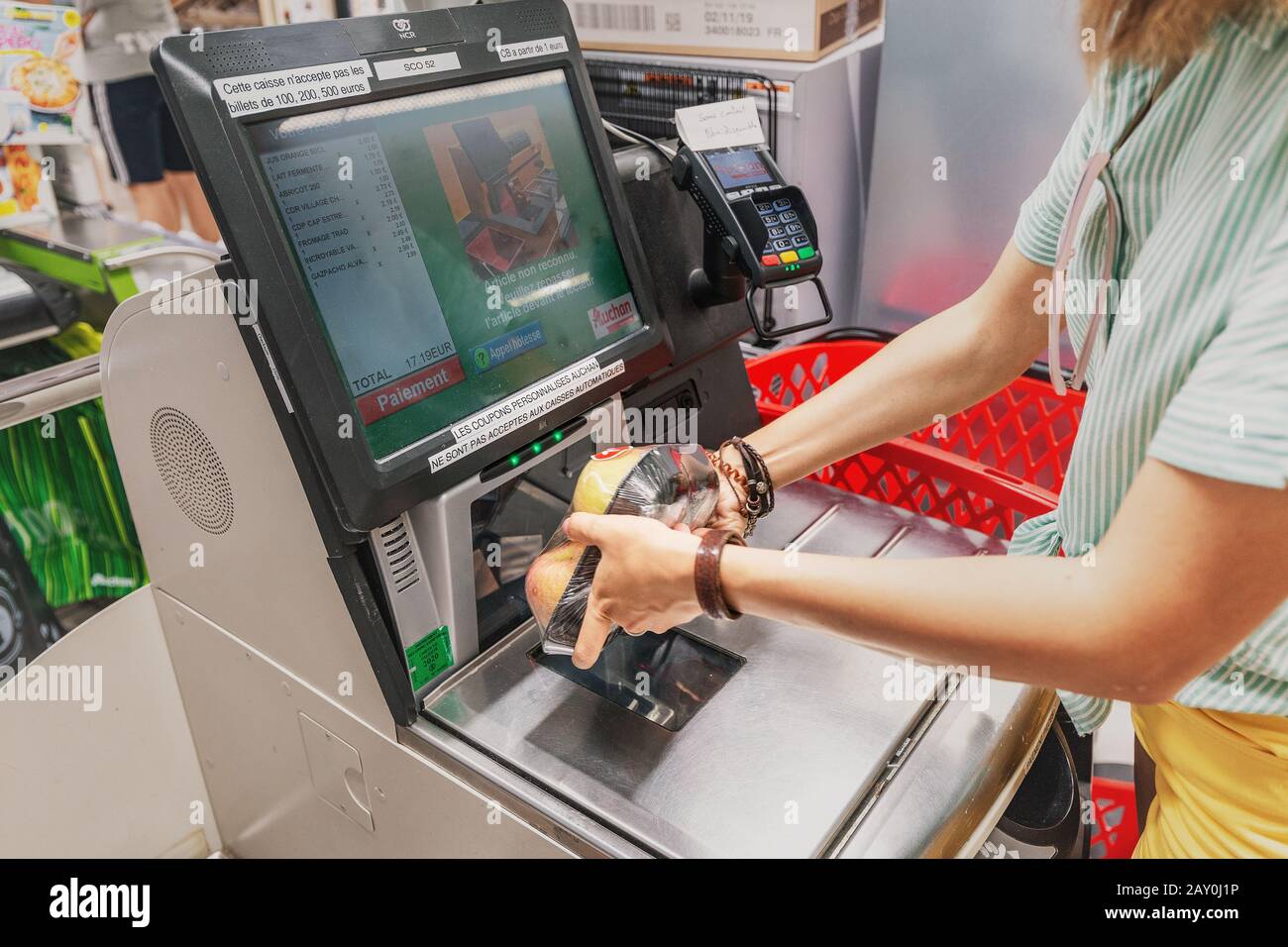 23. Juli 2019, Auchan Supermarket, Lyon, Frankreich: Girl-Kunde scannt Produkte an der Selbstbedienungskasse im Lebensmittelgeschäft Stockfoto